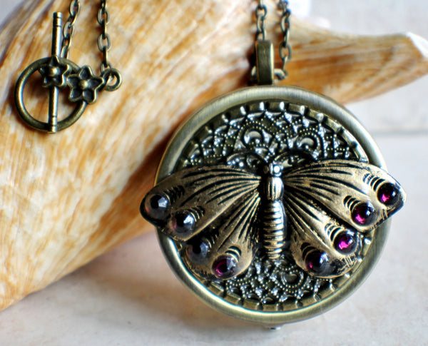 Music box locket,  round locket with music box inside, in bronze with filigree and butterfly adorning front cover. - Char's Favorite Things - 1