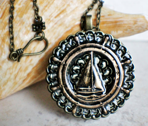 Music box locket, round bronze locket with music box inside, with a nautical theme featuring a sailboat on front cover. - Char's Favorite Things - 1